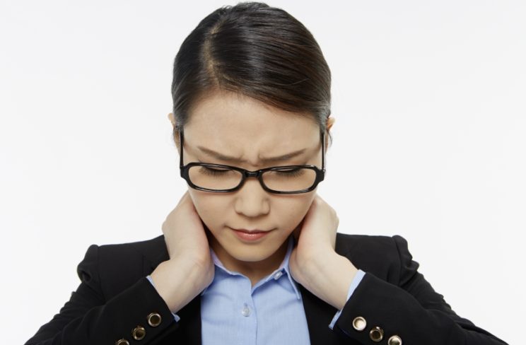 Businesswoman touching her neck